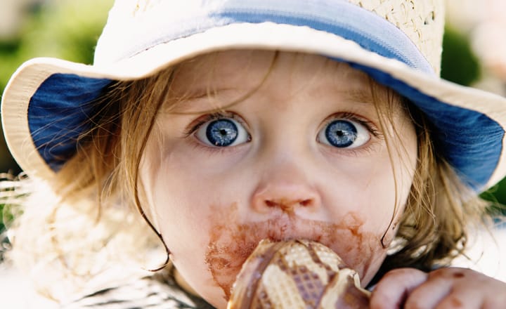 una niña con la cara manchada de consumir helado