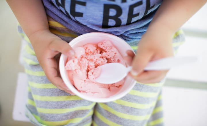 un niño comiendo helado con tarrina